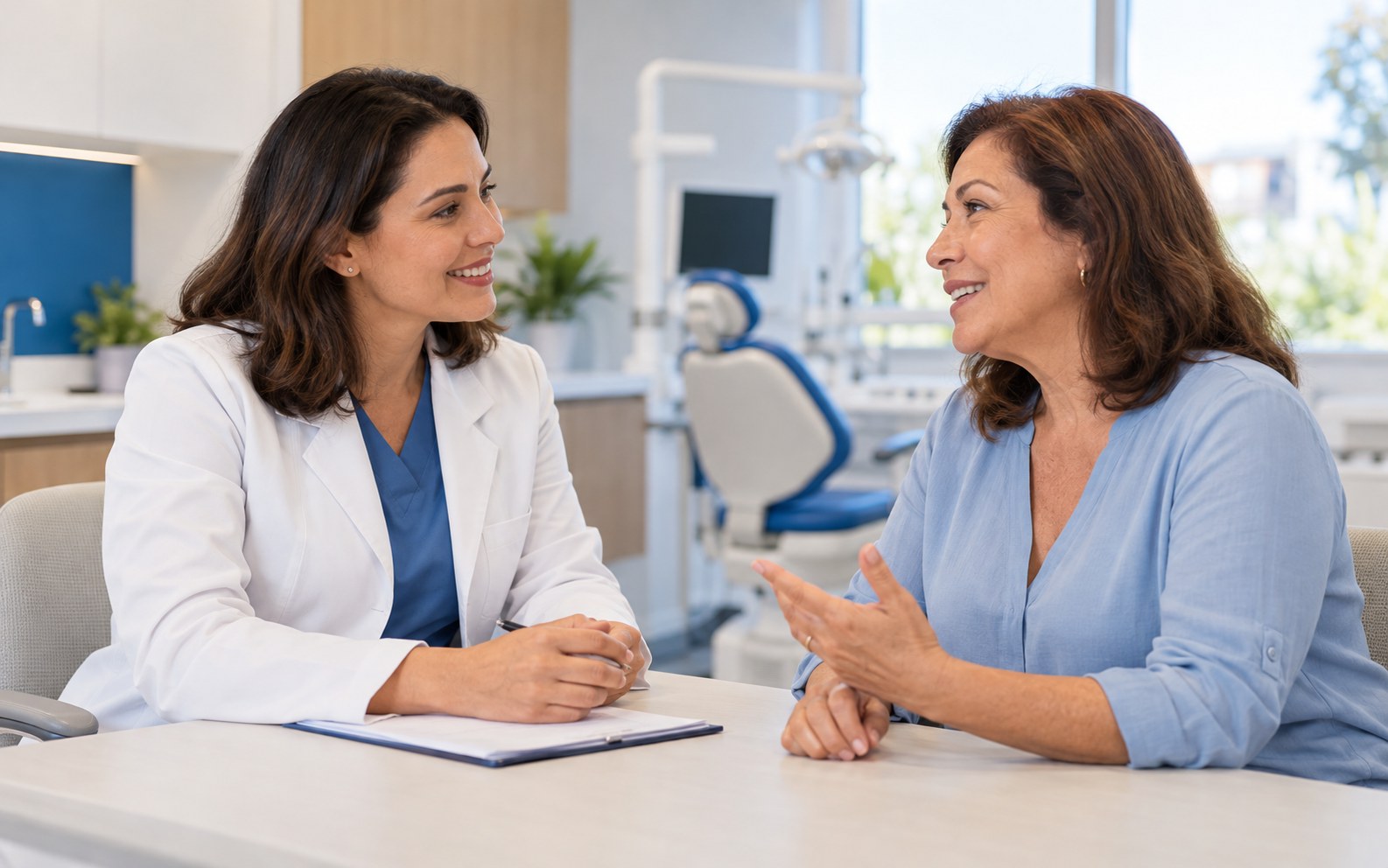 Dentista conversa com paciente em consultório odontológico.